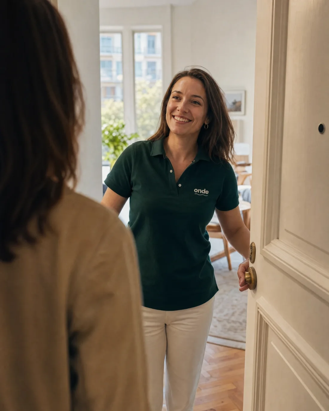 Hôtesse ONDE ouvrant la porte d'un appartement à une propriétaire