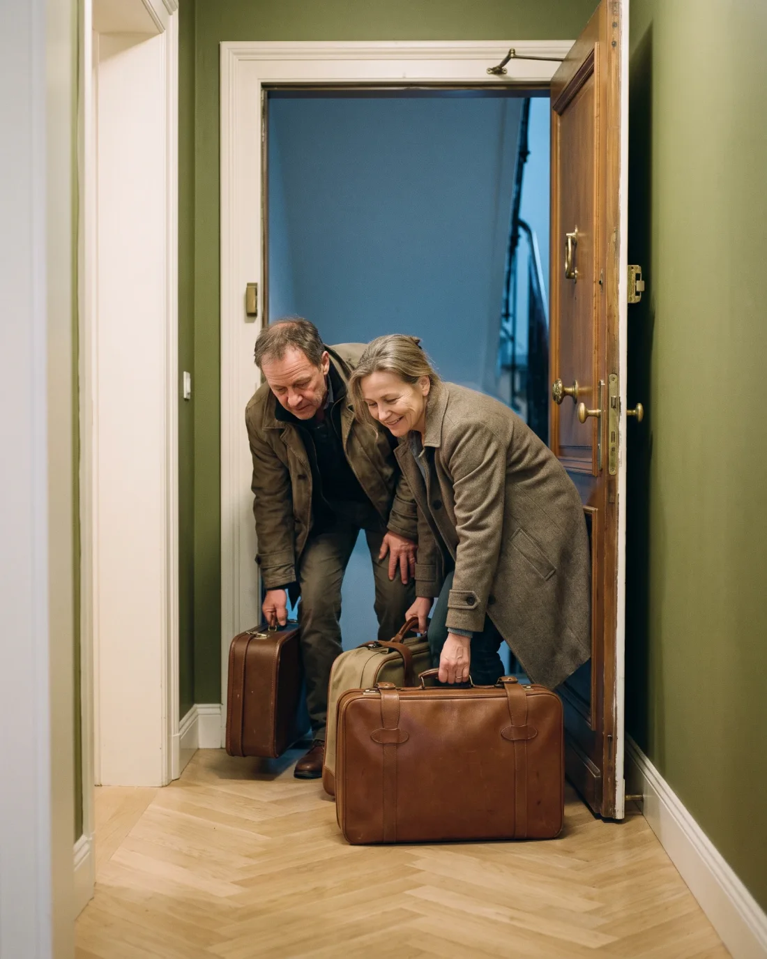 Couple de voyageurs arrivant avec ses valises dans un appartement